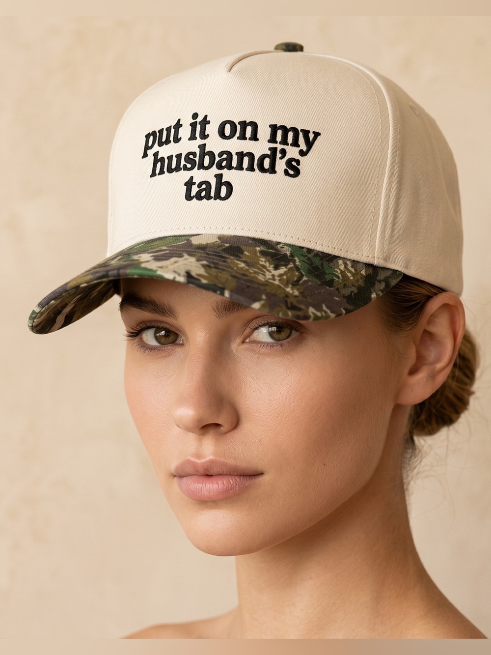 Put It On My Husband’s Tab Trucker Hat Crean & Black Embroidered Graphic Camo
